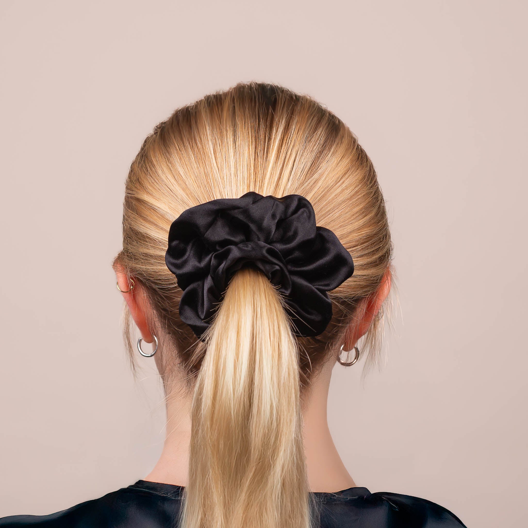 Back view of the Large Silk Scrunchie in Black, securing hair in a high ponytail, with a soft sheen and drape.