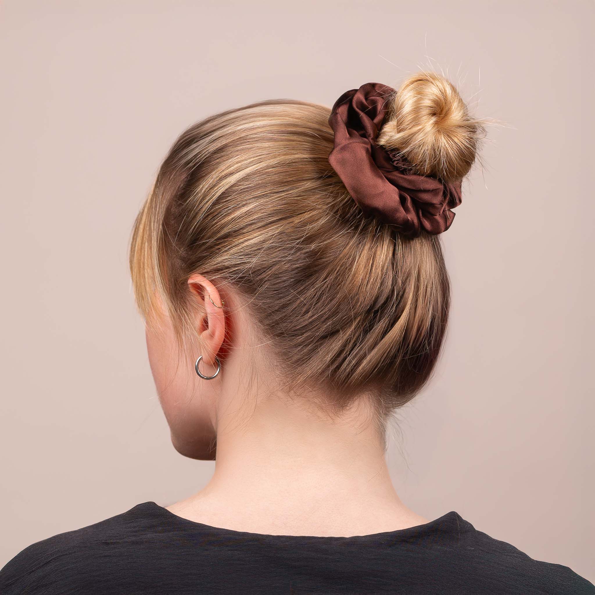 Side view of the Large Silk Scrunchie in Dark Brown securing hair in a high bun, showing its soft sheen and gentle drape.