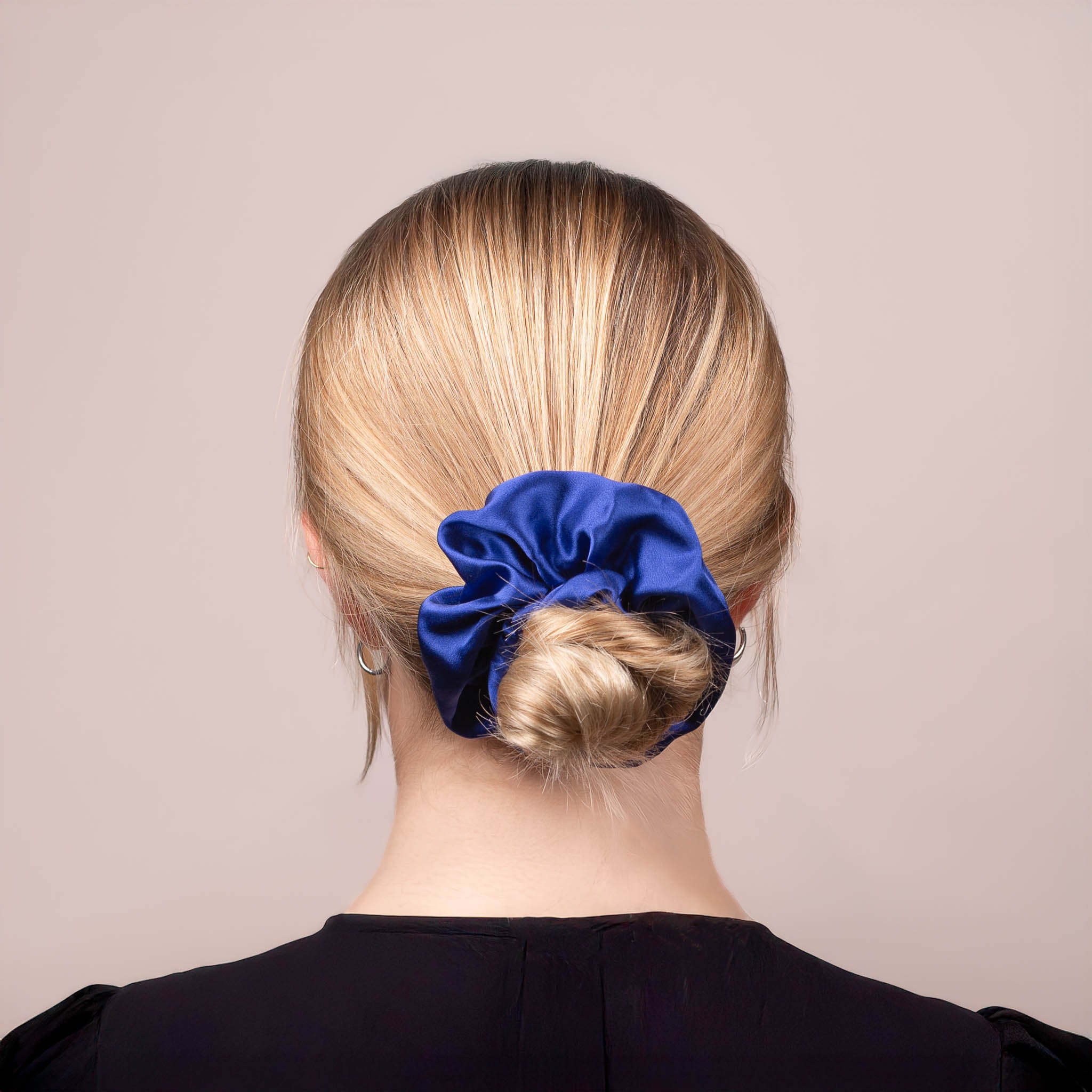 Back view of the Large Silk Scrunchie in Navy Blue securing hair in a low bun, showing its soft sheen and gentle drape.