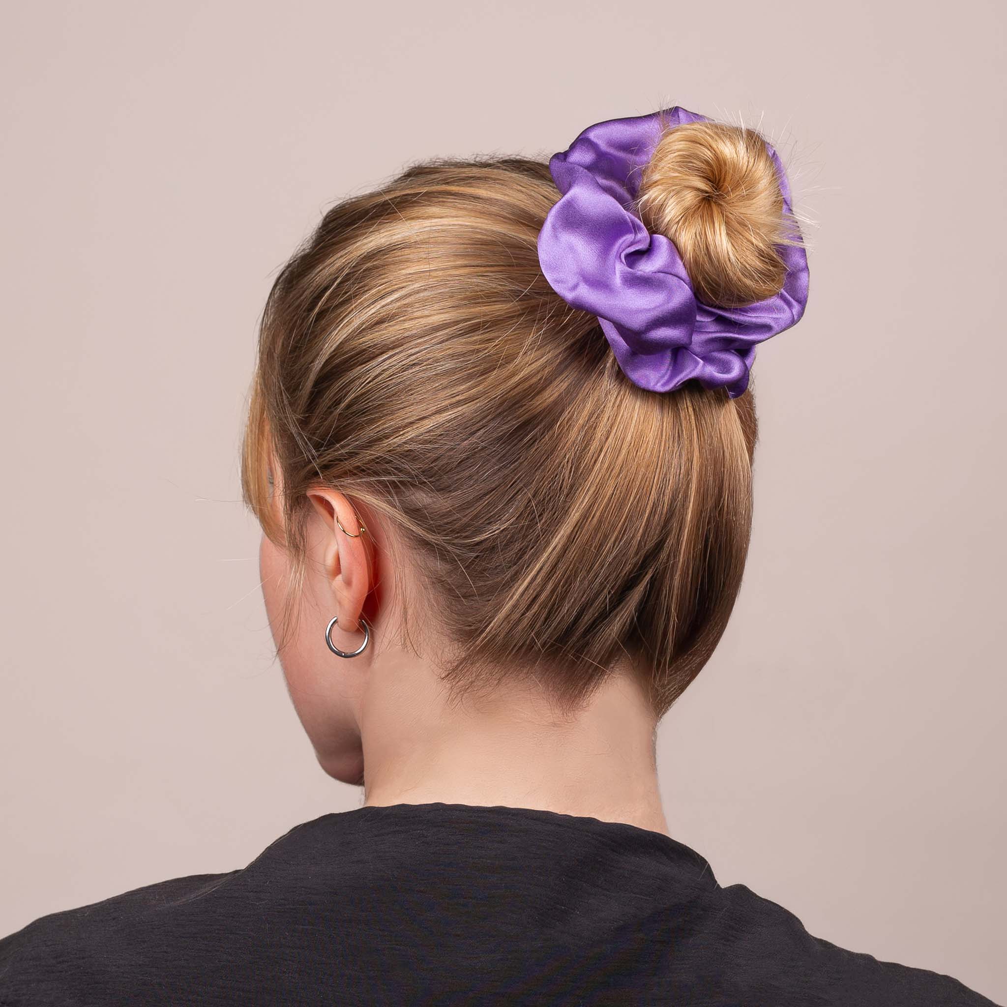 Side view of the Large Silk Scrunchie in Royal Purple securing hair in a high bun, showing its soft sheen and gentle drape.