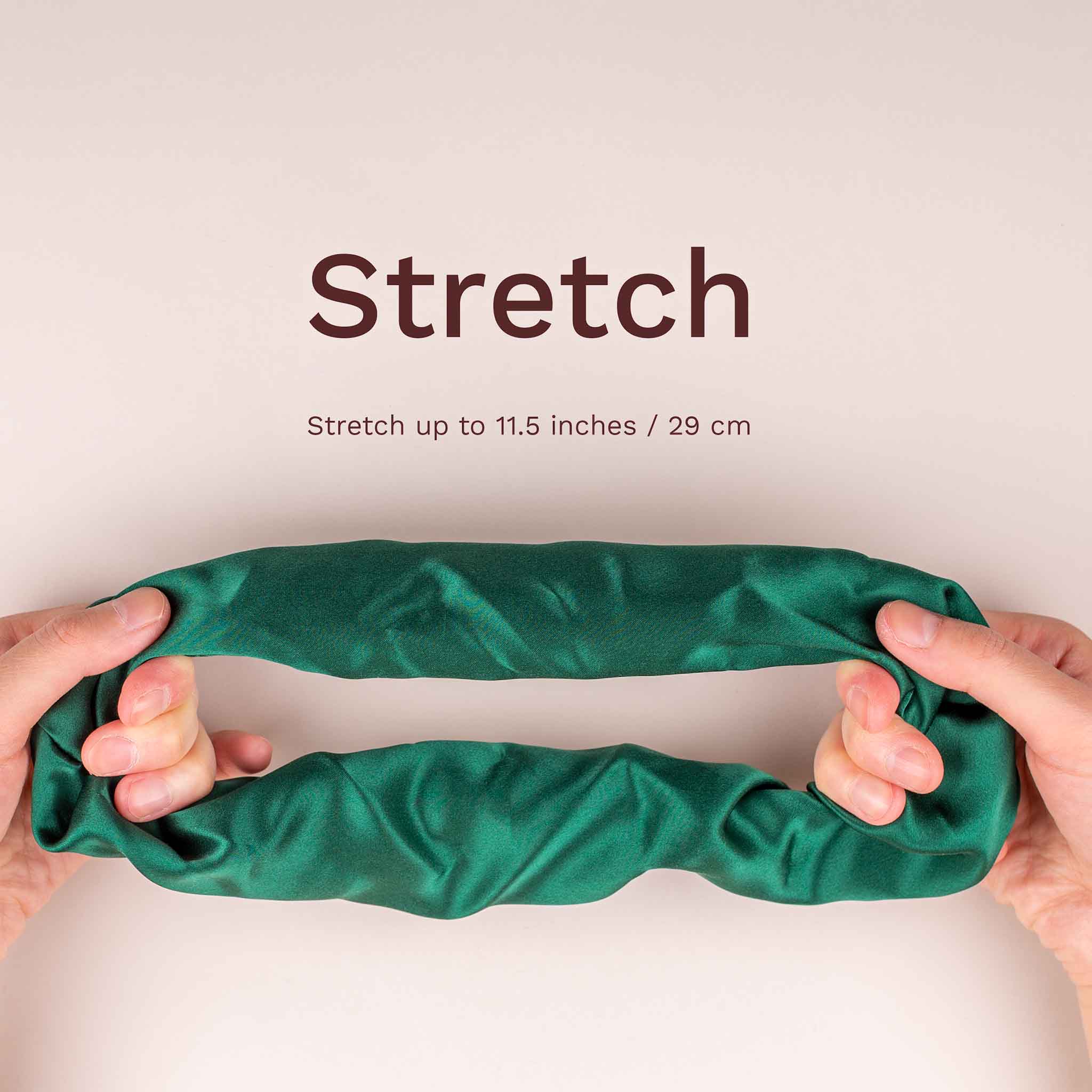 Large silk scrunchie shown stretched between hands, stretching up to 11.5 inches (29 cm).