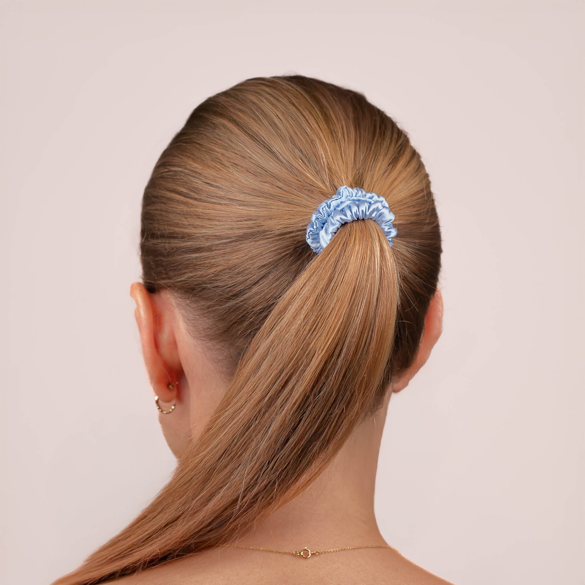 Skinny Silk Scrunchie in Icy Blue securing a high ponytail, shown from the back, highlighting its smooth texture and soft sheen.