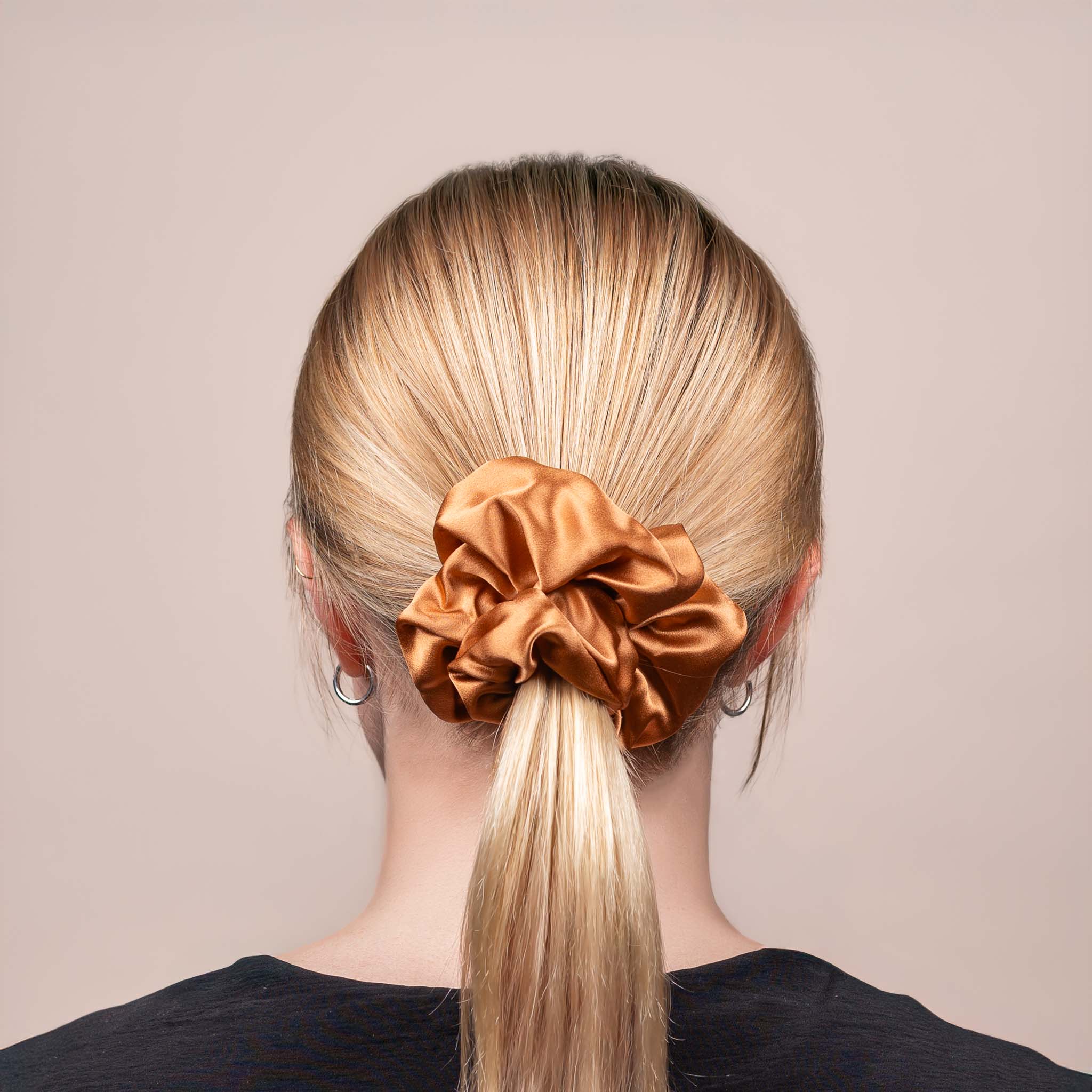 Back view of the Large Silk Scrunchie in Caramel Brown, securing hair in a low ponytail, with a soft sheen and drape.