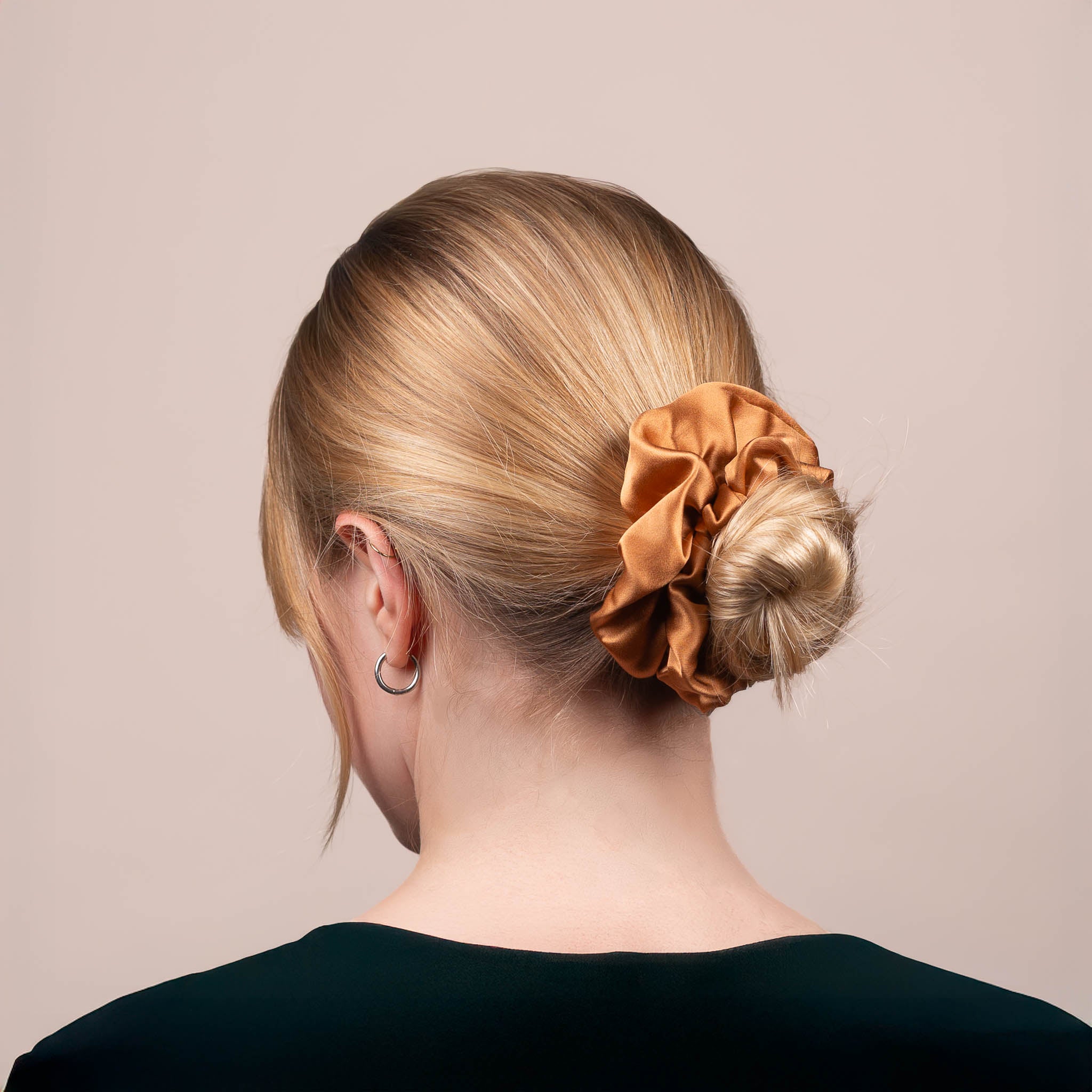 Back view of the Large Silk Scrunchie in Caramel Brown securing hair in a low bun, showing its soft sheen and gentle drape.
