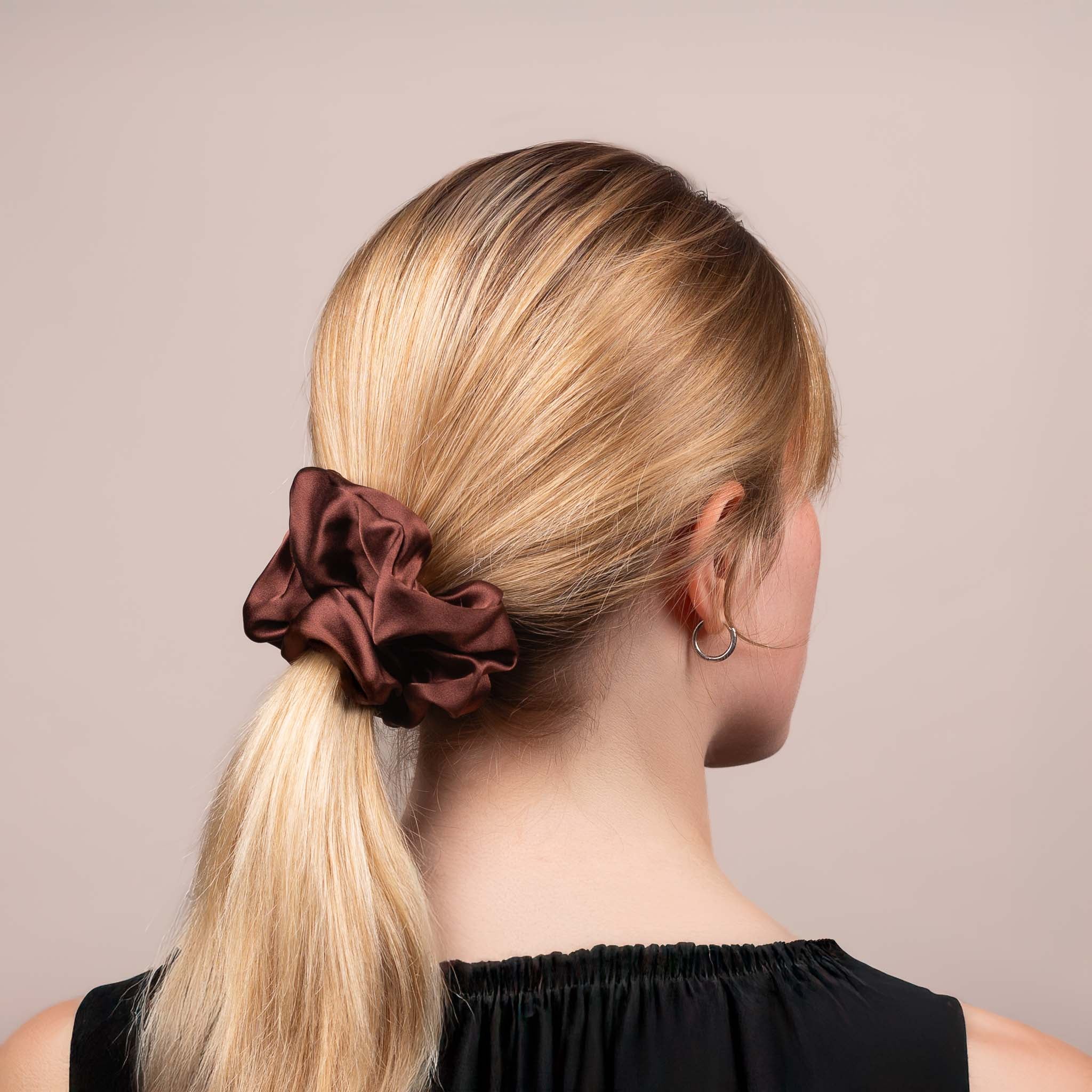 Side view of the Large Silk Scrunchie in Dark Brown securing hair in a low ponytail, with a soft sheen and drape.