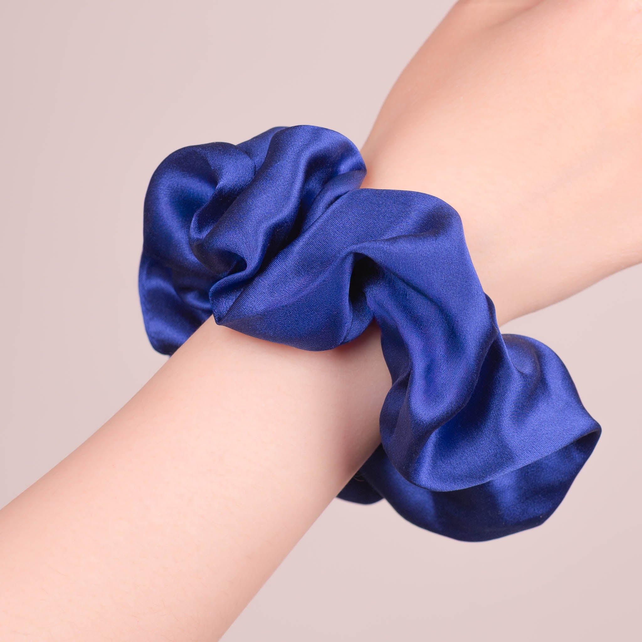 Large Silk Scrunchie in Navy Blue—a deep cool navy blue—worn on a wrist, showing a natural soft sheen and gentle drape.