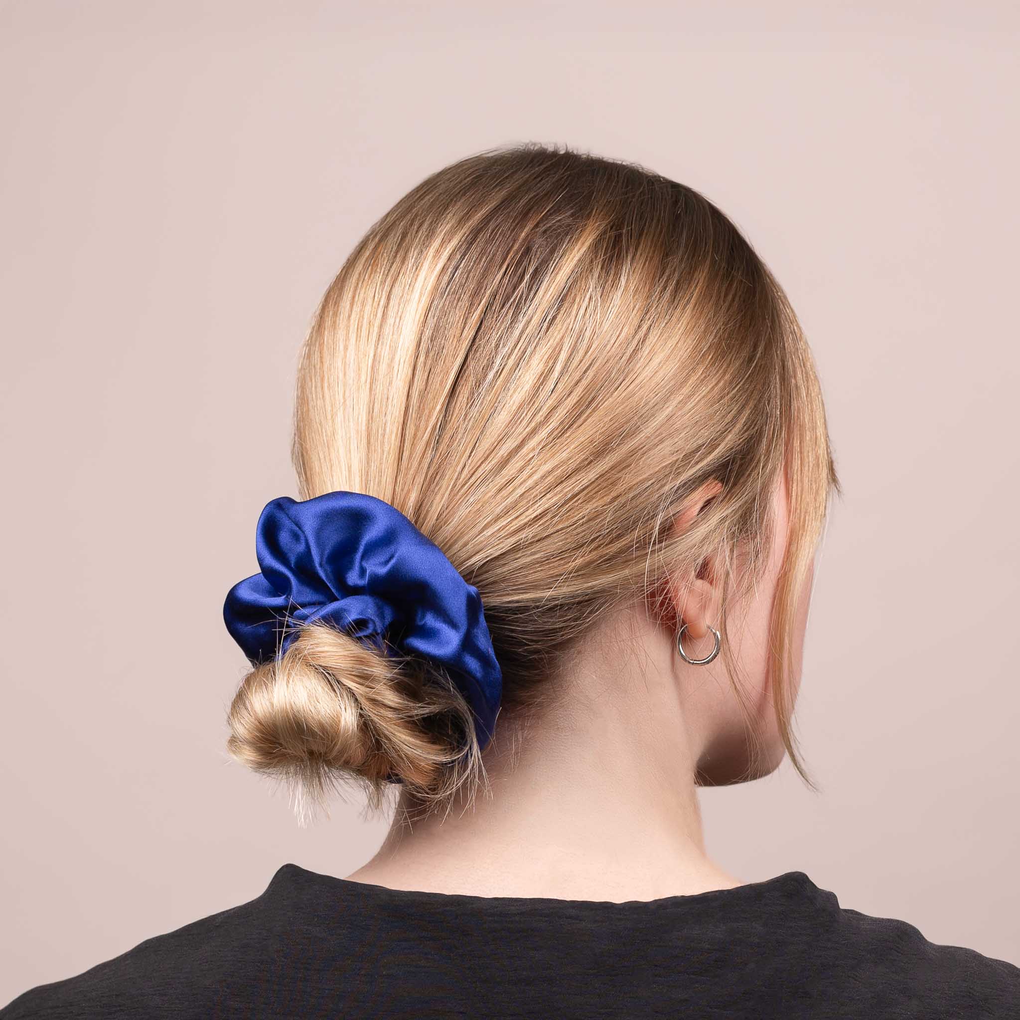 Side view of the Large Silk Scrunchie in Navy Blue securing hair in a low bun, showing its soft sheen and gentle drape.