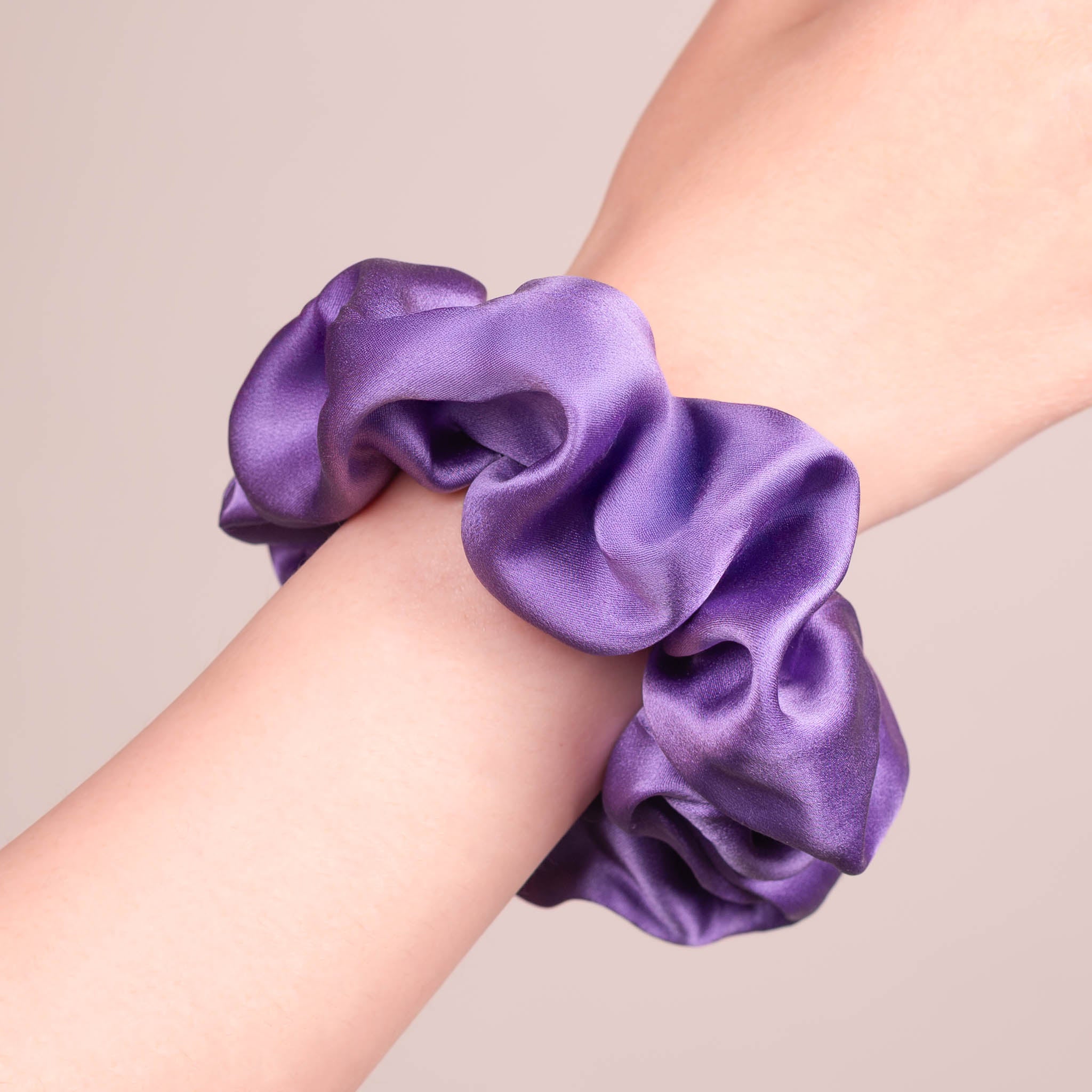 Large Silk Scrunchie in Royal Purple—a deep jewel-toned purple —worn on a wrist, showing a natural soft sheen and gentle drape.