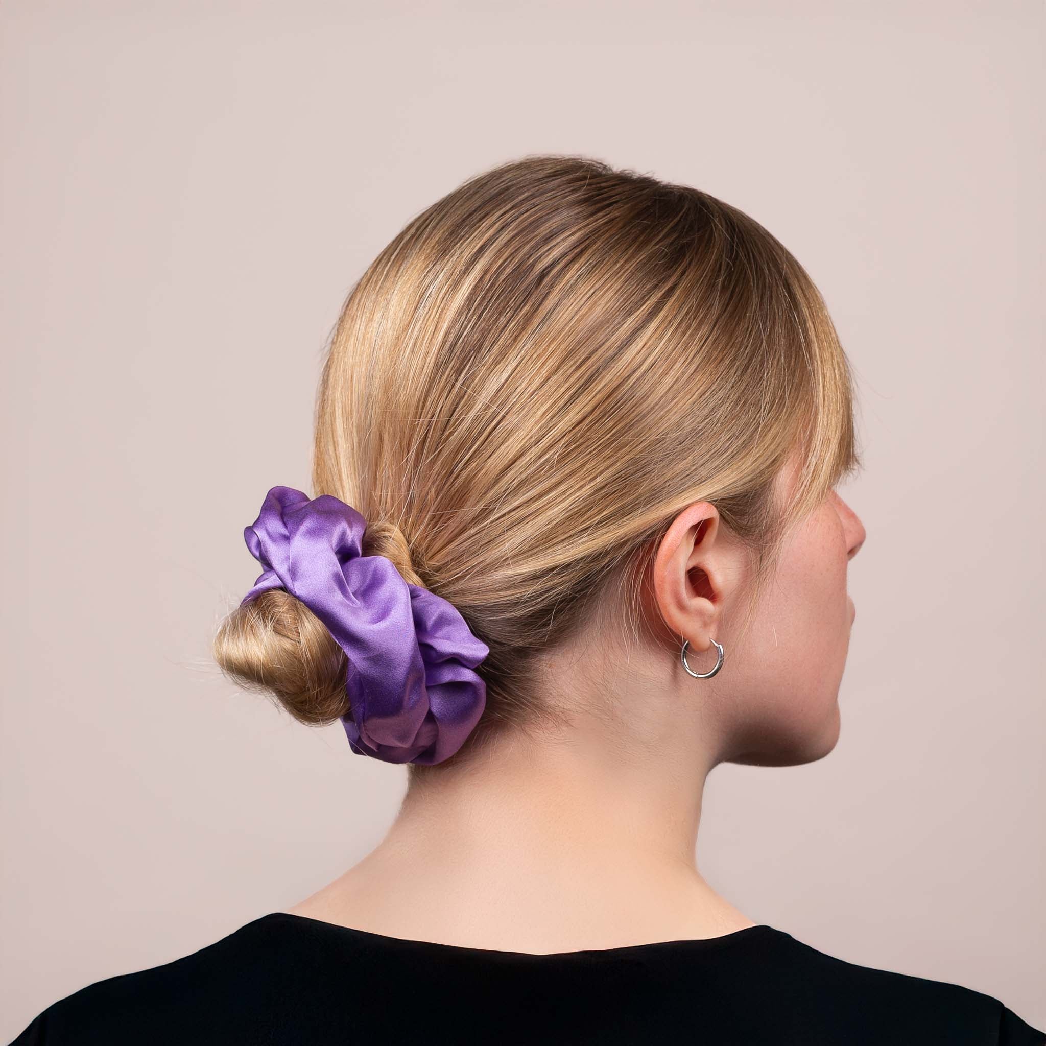 Side view of the Large Silk Scrunchie in Royal Purple securing hair in a low bun, showing its soft sheen and gentle drape.