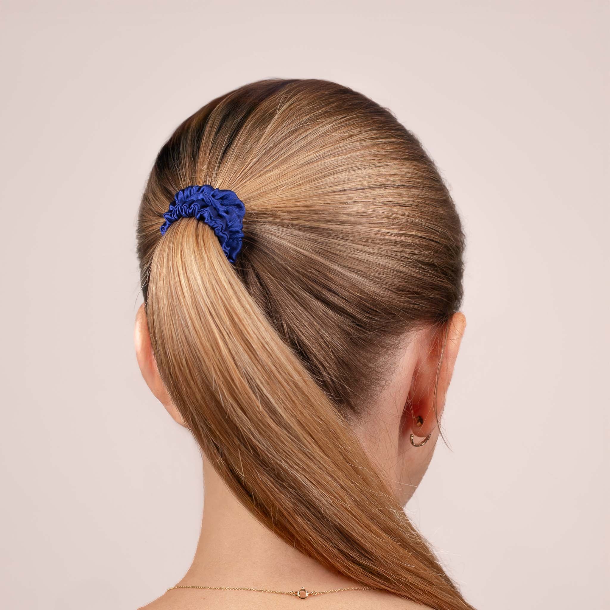 Skinny Silk Scrunchie in Navy Blue securing a high ponytail, shown from the back, highlighting its smooth texture and soft sheen.