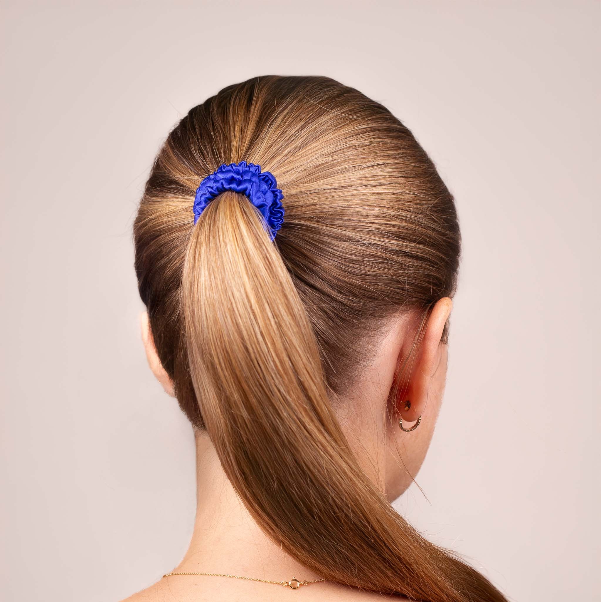 Skinny Silk Scrunchie in Royal Blue securing a high ponytail, shown from the back, highlighting its smooth texture and soft sheen.